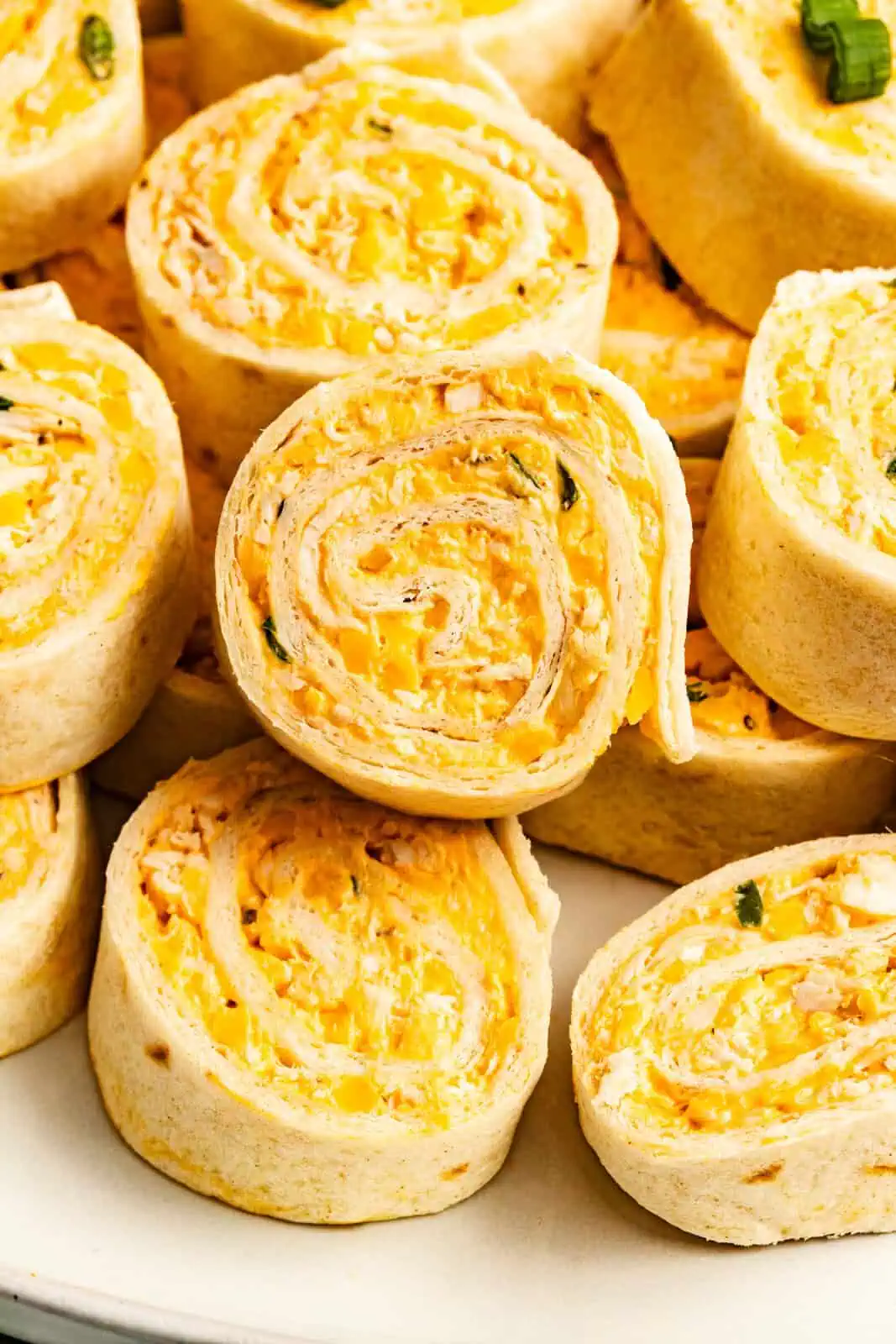 Close up of buffalo chicken pinwheel slices, showing the pinwheel pattern in the roll ups.