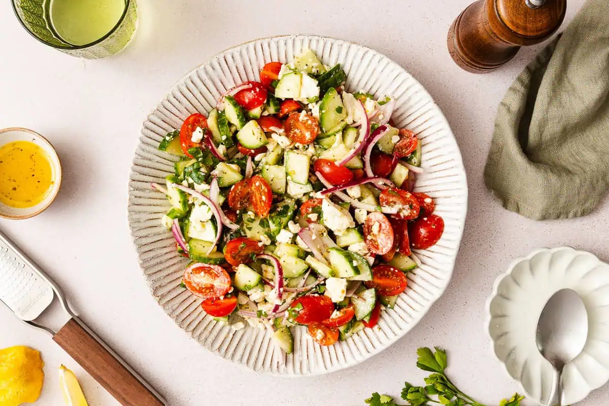 Overhead view of a large serving bowl filled with cucumber feta salad.