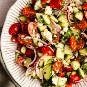 Serving platter filled with cucumber feta salad.