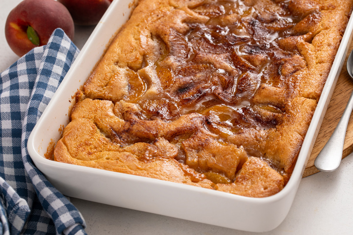 Close up of baked peach cobbler in a baking dish.