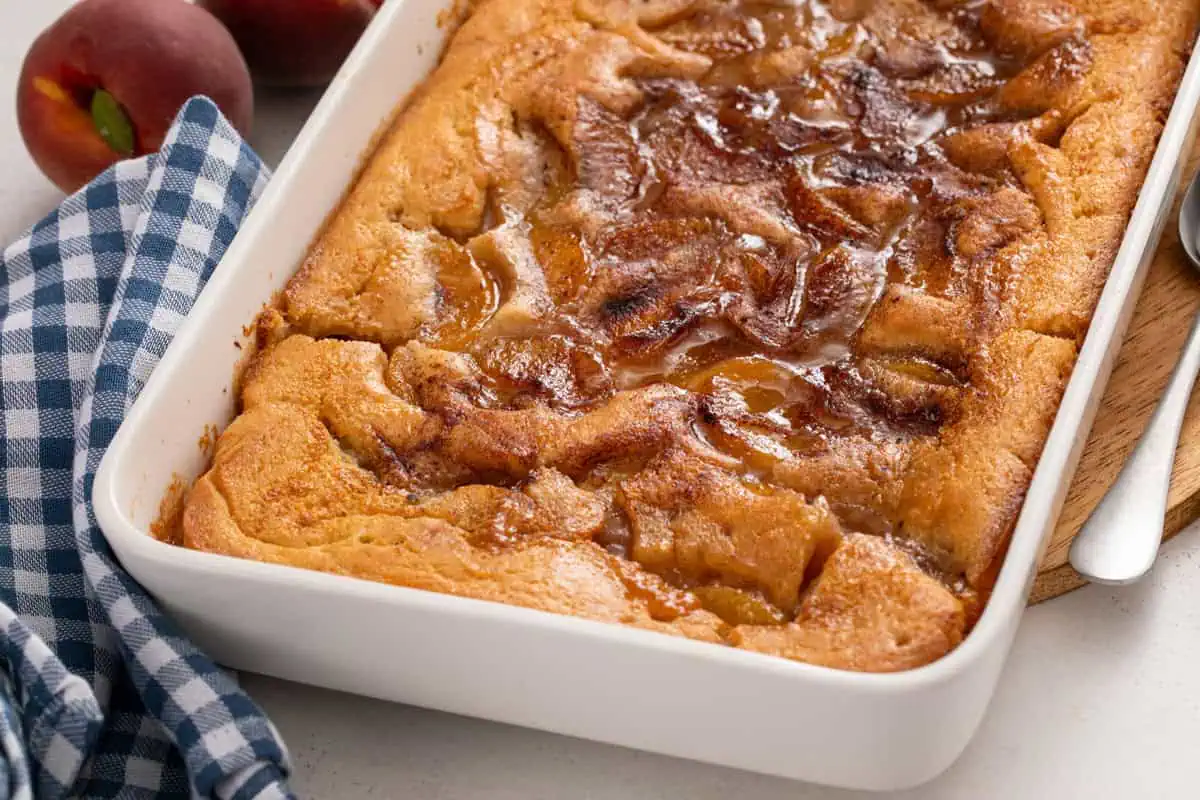 Close up of baked peach cobbler in a baking dish.