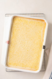 Baked lemon bars cooling in a white baking pan.