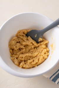 Soft dough for lemon bar crust stirred together in a mixing bowl.