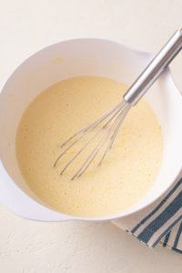 Lemon bar filling whisked together in a bowl.