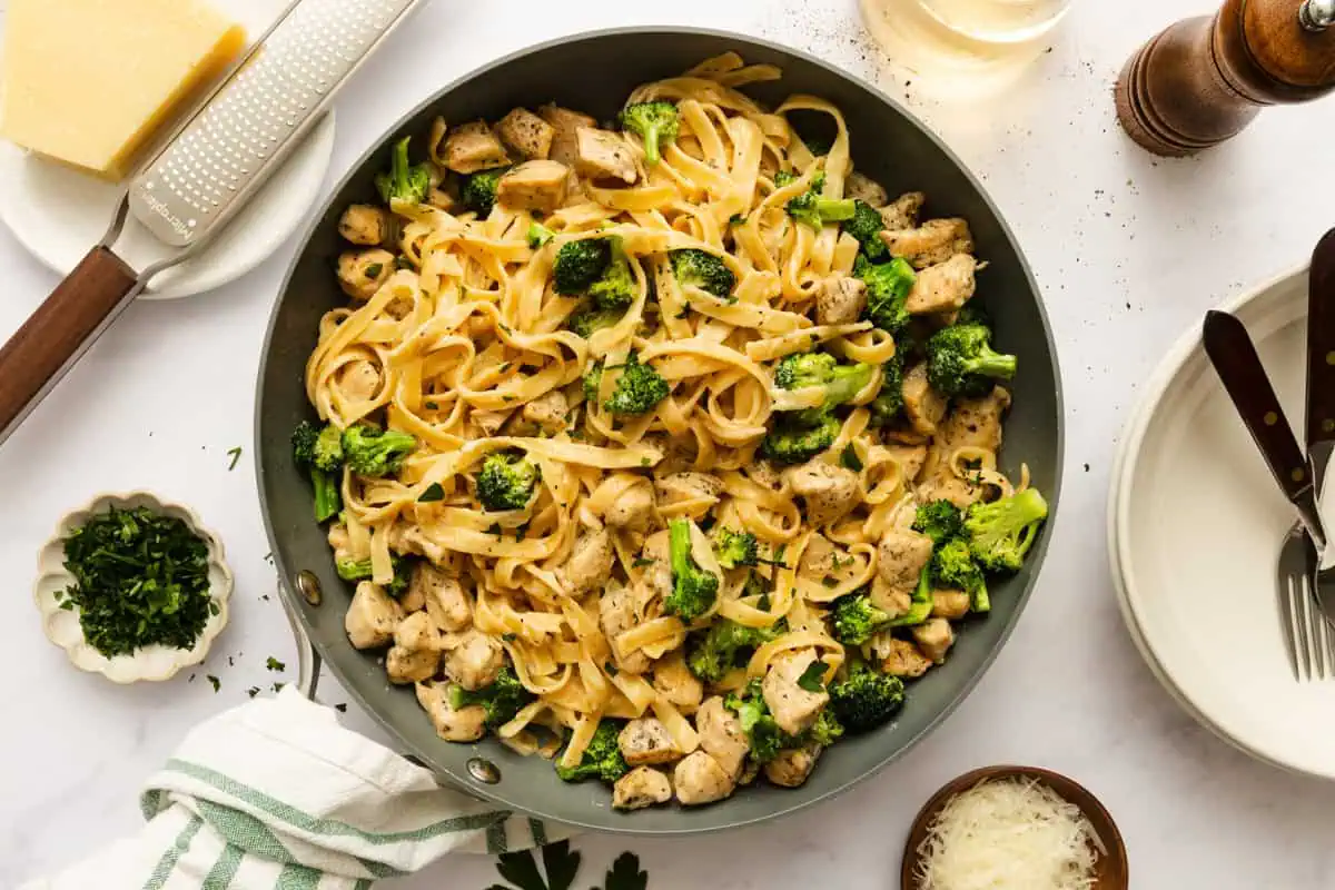 Overhead view of chicken and broccoli alfredo in a skillet, set on a countertop.