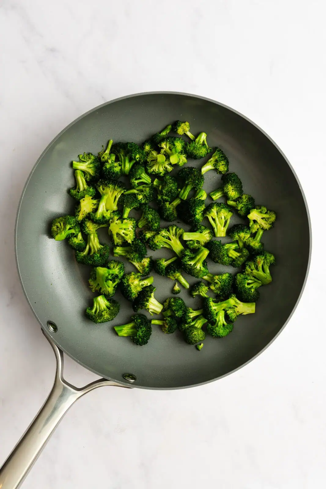 Sauteed broccoli florets in a skillet.