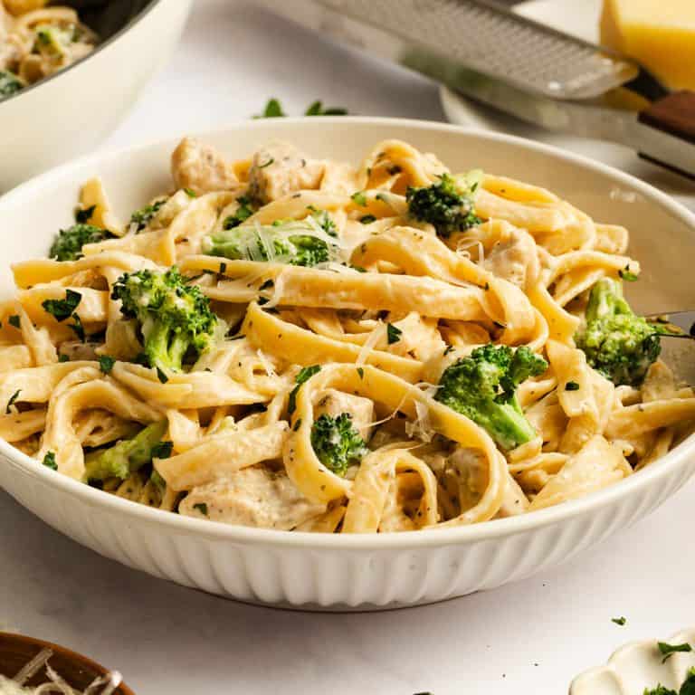 Close up of a bowl of chicken and broccoli alfredo.