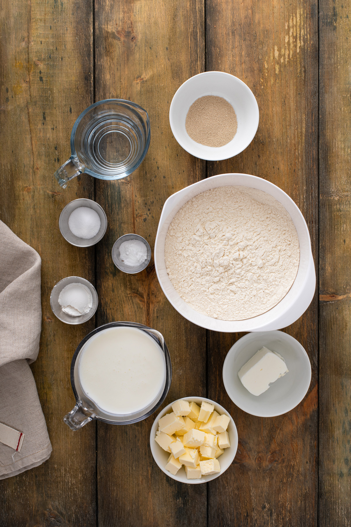 Ingredients for angel biscuits arranged on a wooden countertop.