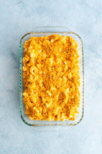 Smoked gouda mac and cheese assembled in a glass baking dish, ready to go in the oven.