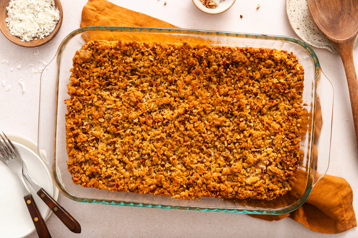 Casserole dish of sweet potato casserole with streusel topping resting on a countertop.