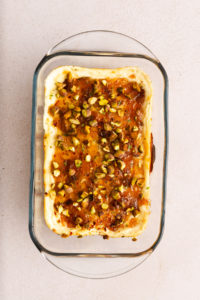 Baked goat cheese dip garnished with chopped pistachios and fresh thyme.