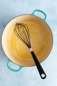 Roux for cheese sauce for smoked gouda mac and cheese whisked in a dutch oven.