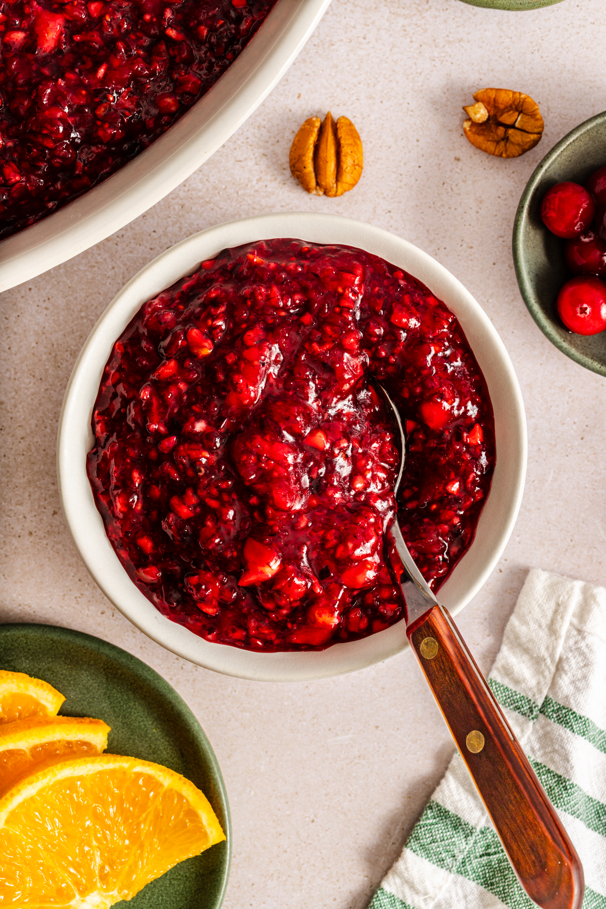 Spoon in a small white bowl of cranberry jello salad.