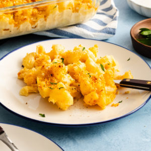White plate holding a serving of smoked gouda mac and cheese and a fork.