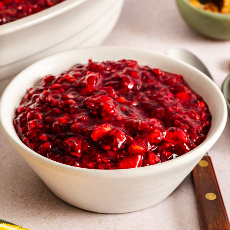 Cranberry jello salad in a small white bowl.
