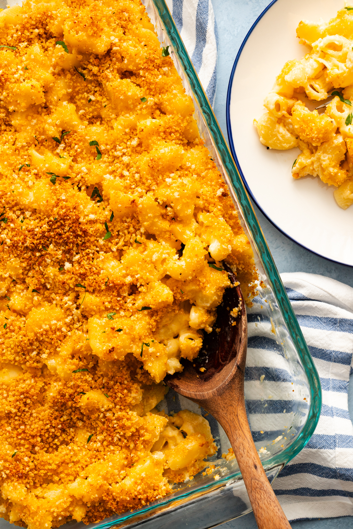 Overhead view of a wooden spoon in the corner of a baking dish of smoked gouda mac and cheese.