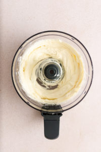 Goat cheese, cream cheese, and honey mixed in the bowl of a food processor until smooth and creamy.